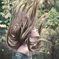 photo of woman with her hair flying upwards in air