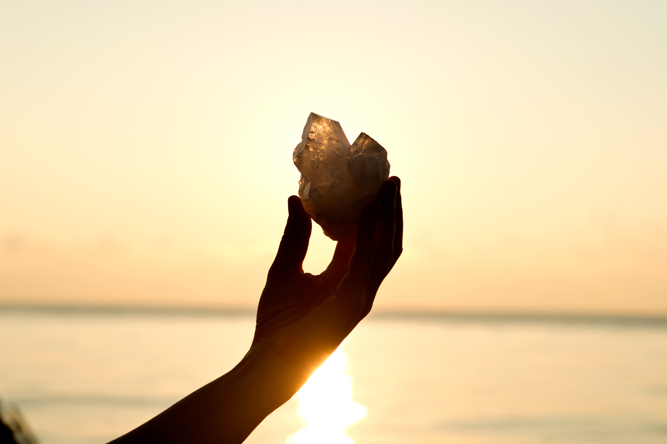 Woman's hands holding clear quartz point
